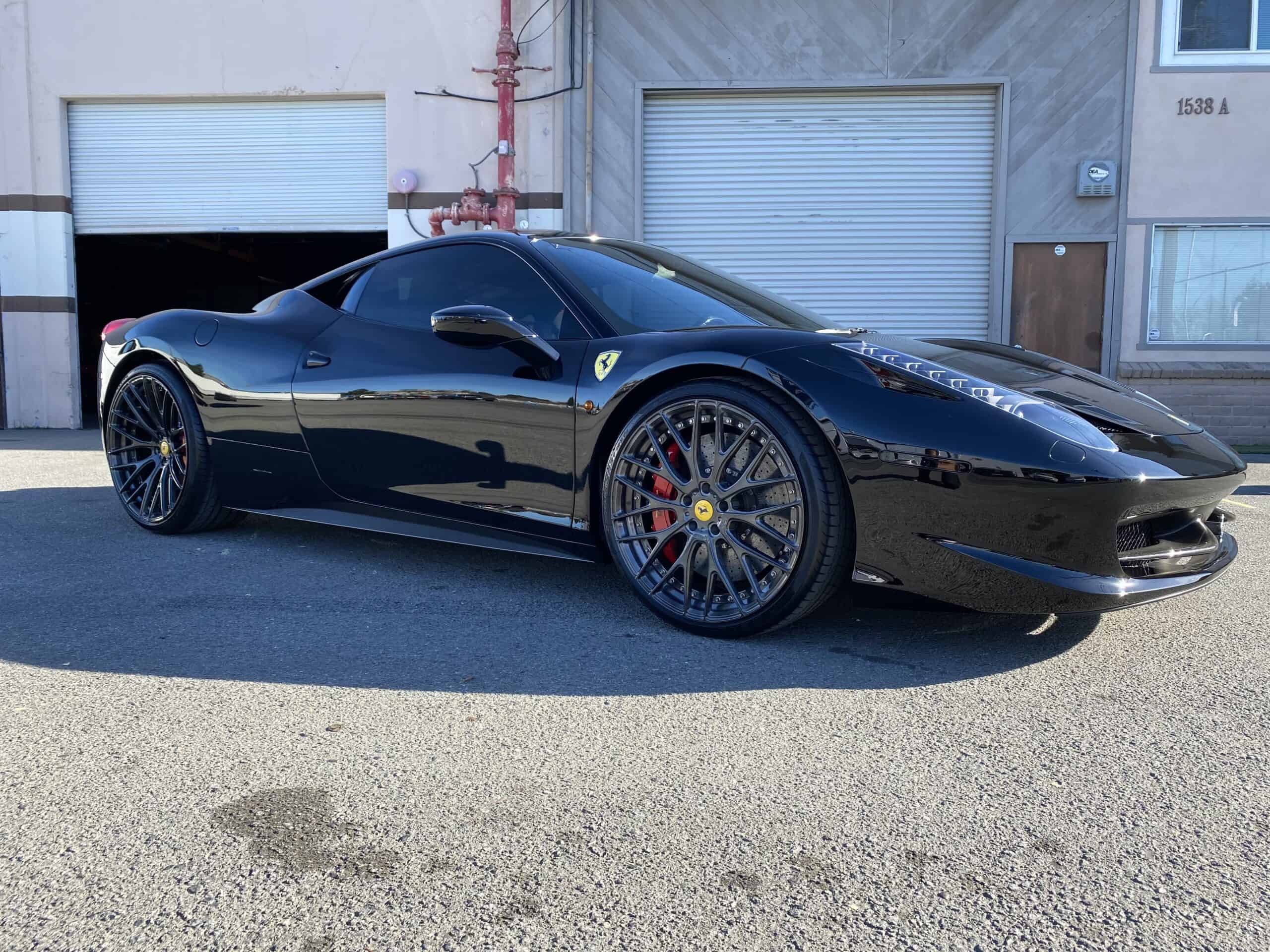 a black sports car parked in front of a garage